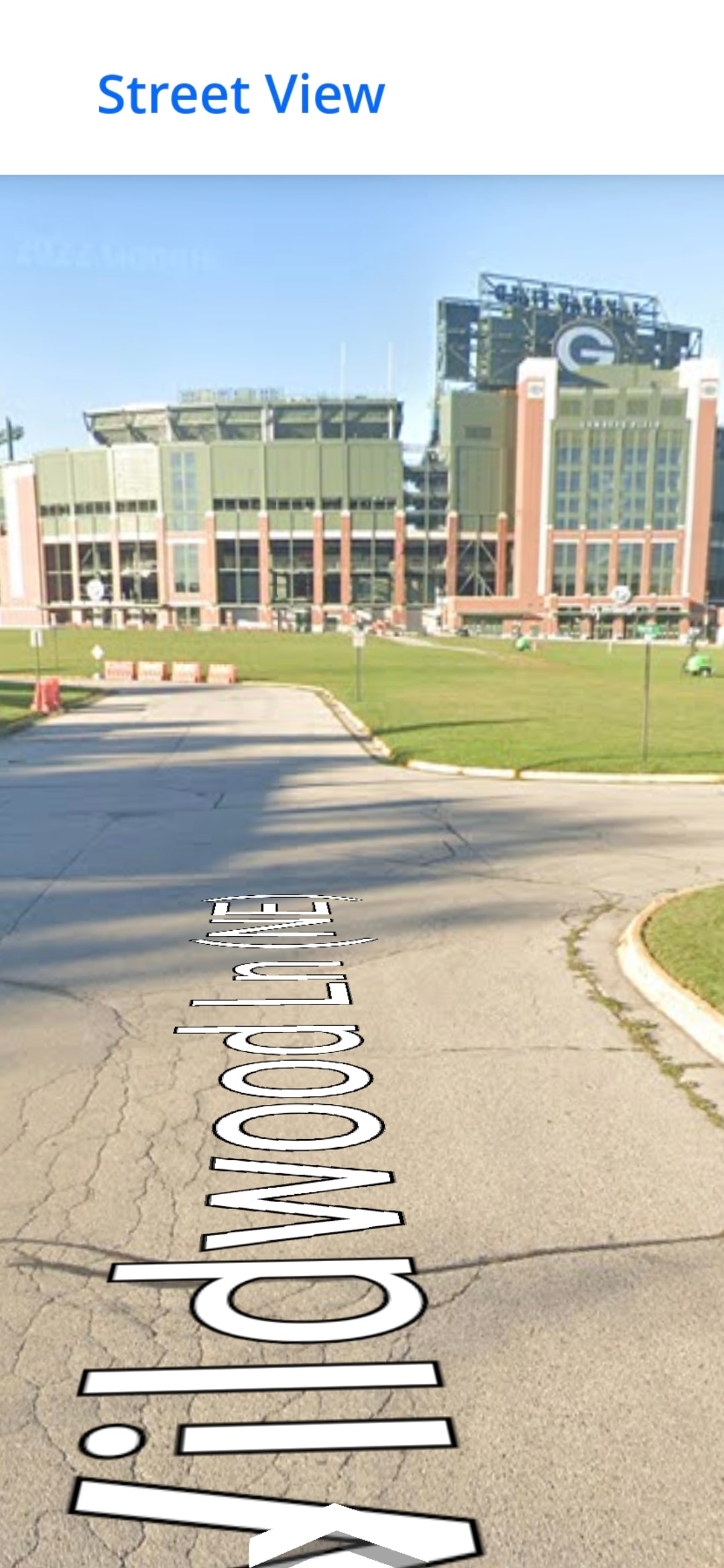 Street view of 2077 Wildwood Lane showing the parking lot entrance near Lambeau Field